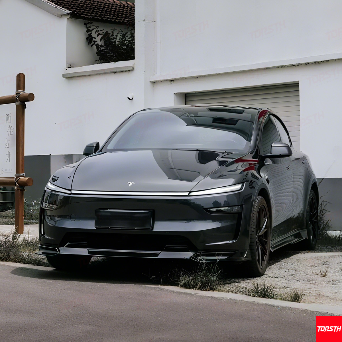 Black electric car parked in front of a white building