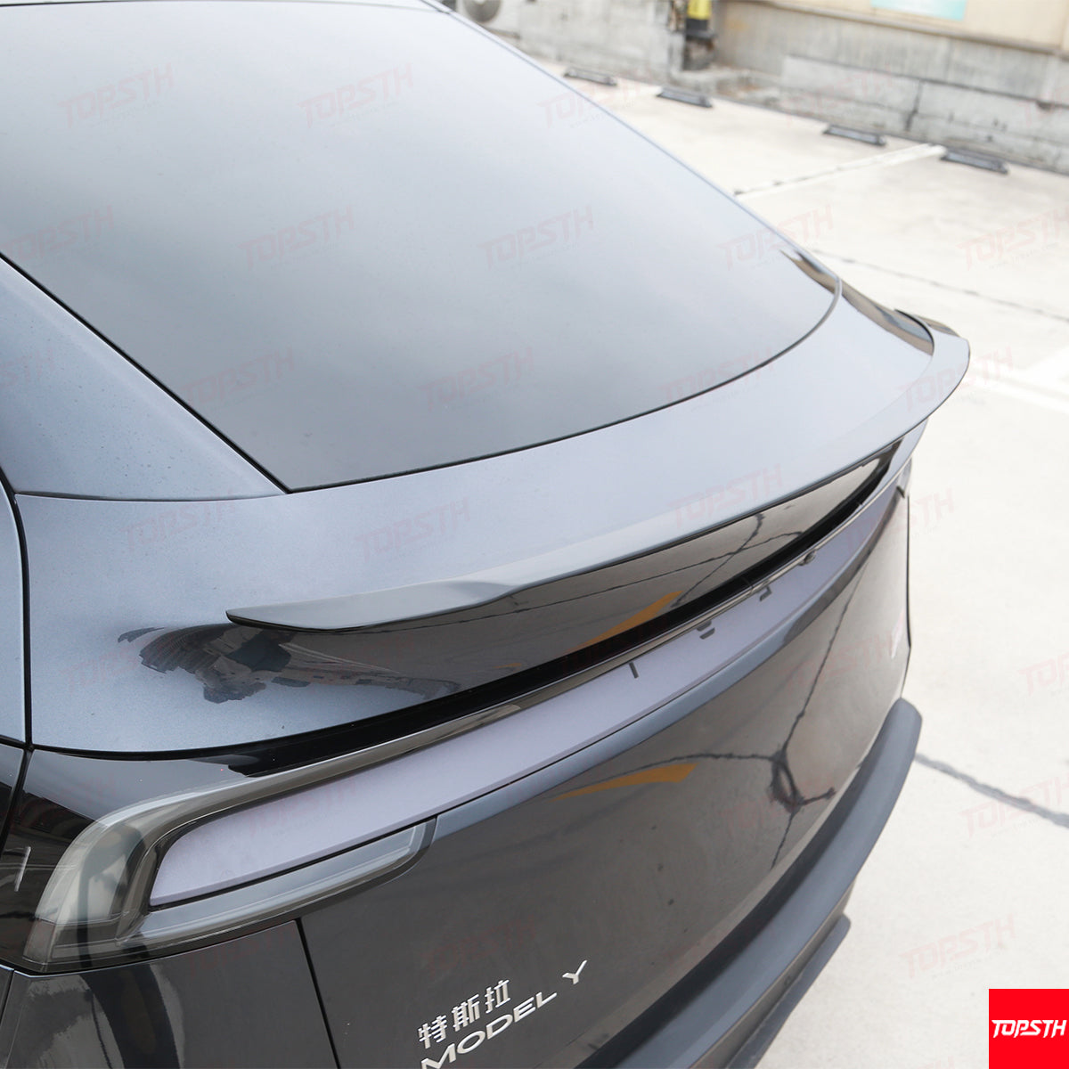 Rear view of the gloss black OEM Performance Pro Style spoiler installed perfectly on a Tesla Model Y Juniper trunk.