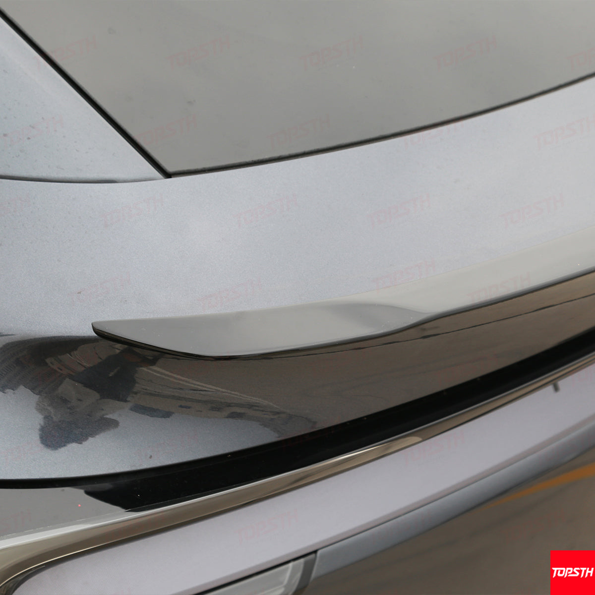 Close-up of the gloss black OEM Performance Pro Style spoiler installation on the trunk edge of a Tesla Model Y Juniper.