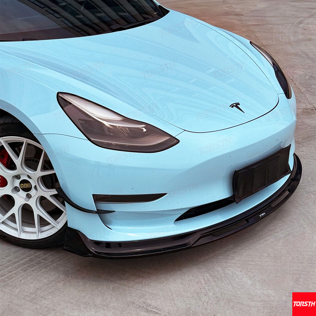 Light blue car with a visible brand logo on a wooden floor
