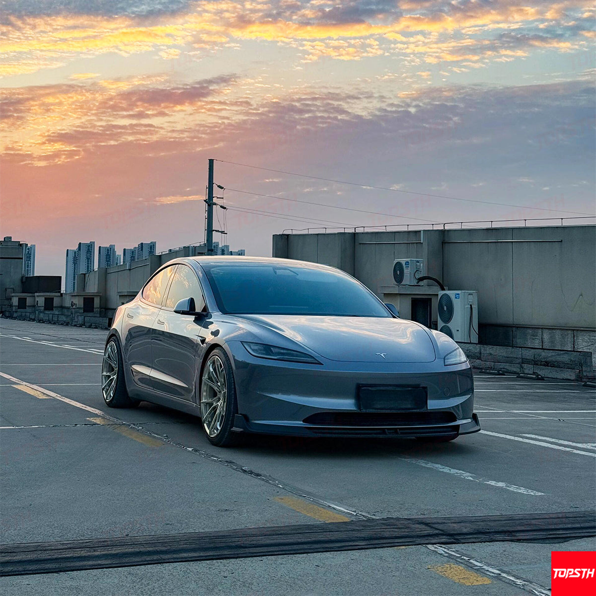 Front three-quarter view of a grey Tesla Model 3 Highland with an ABS plastic aerodynamic body kit.