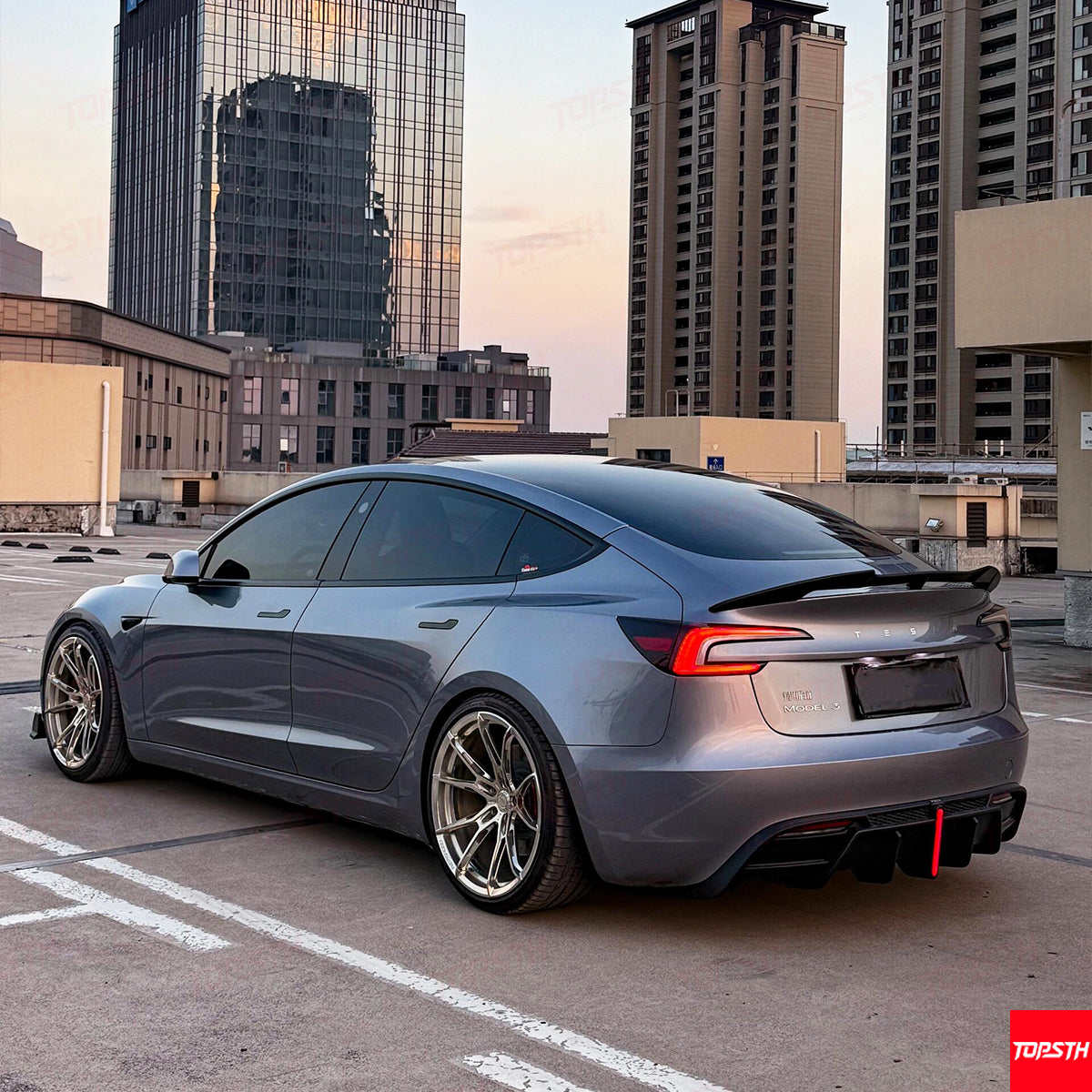 Side view of a modified Tesla Model 3 Highland with custom wheels and ABS lower body extensions.