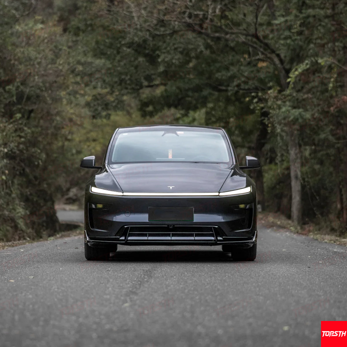 Frontal shot of a black Tesla Model Y modification with sleek LED strip lights and a custom front fascia.