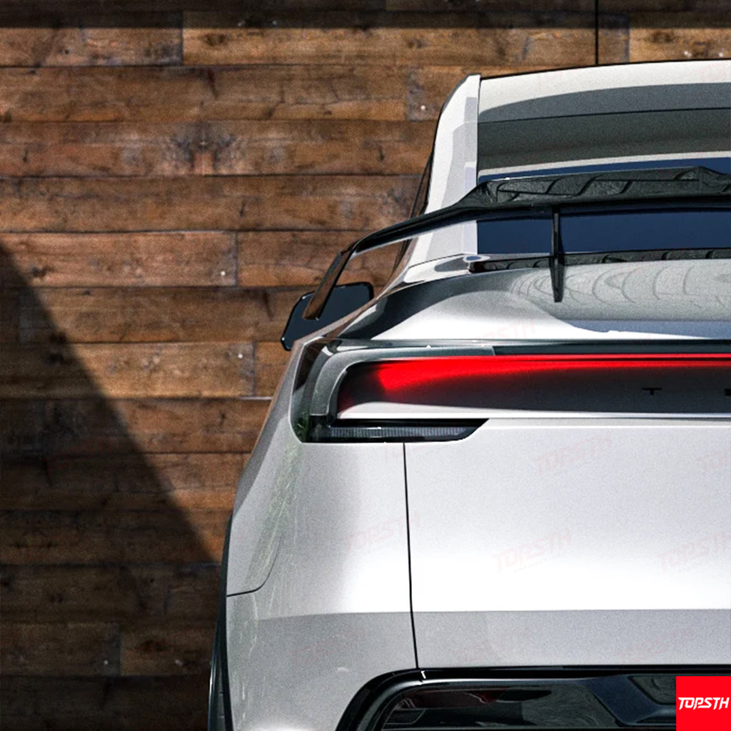 Close-up view of the high-quality carbon fiber weave on a Tesla Model Y rear spoiler.