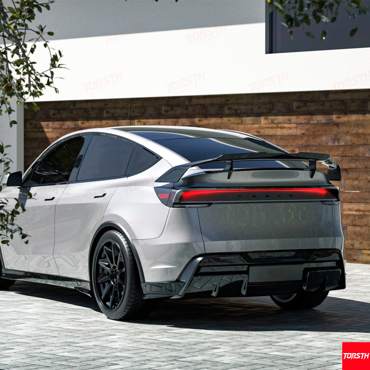 Aggressive performance-style carbon fiber wing installed on a white Tesla Model Y side profile.