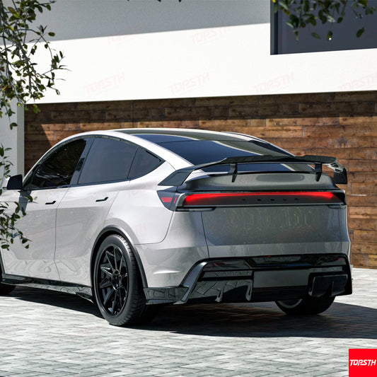 Aggressive performance-style carbon fiber wing installed on a white Tesla Model Y side profile.