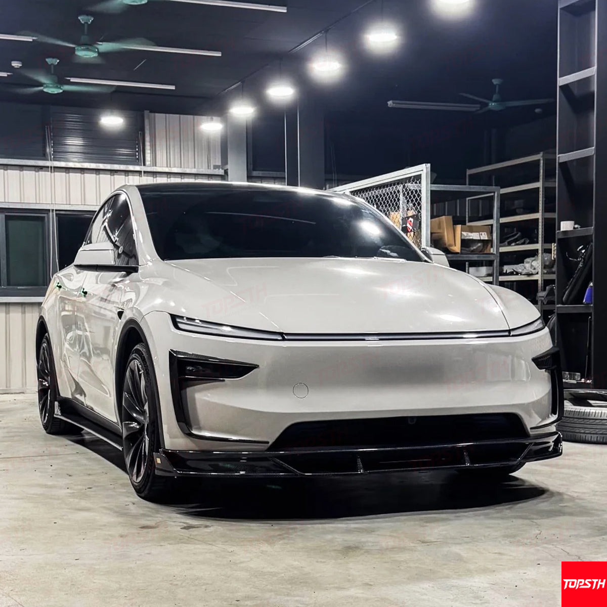 Low-angle front view of the Model Y Juniper 2025+ showing the aggressive stance with the Carbon Fiber EL Design kit.