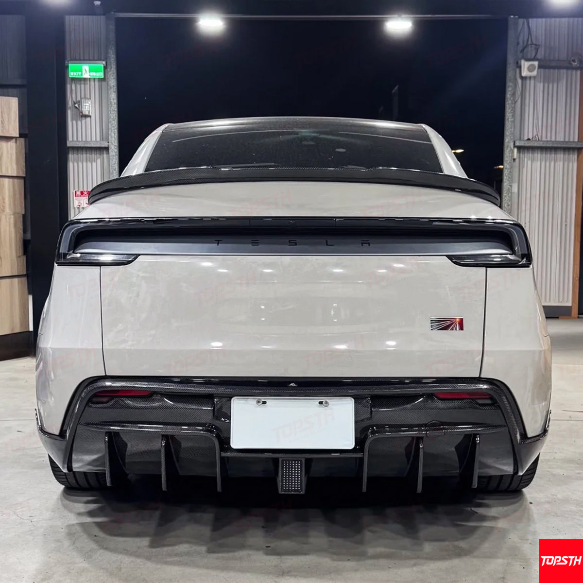 Straight rear view of a white Model Y Juniper 2025+ showcasing the aggressive Carbon Fiber EL Design Rear Diffuser.