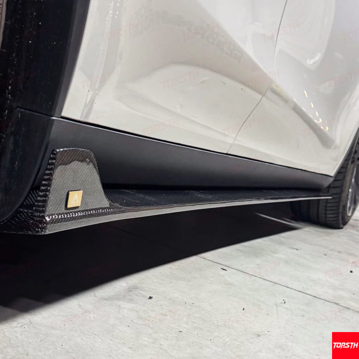 Undercarriage close-up of the secured Carbon Fiber EL Design Side Skirt extension on the Model Y Juniper.